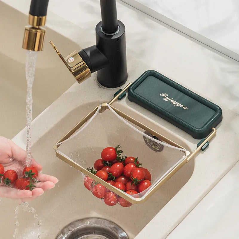 Foldable sink filter rack in dark green gold with disposable mesh bag on a stainless steel sink