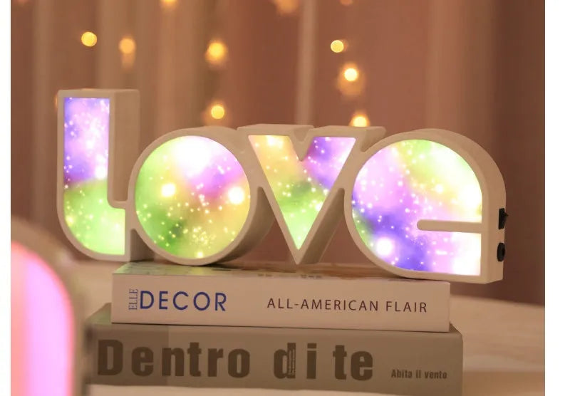Rainbow-coloured plastic LED light spelling LOVE, standing 35.5cm tall on a table.