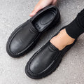 Men's black slip-on work shoes with waterproof platform sole and round toe design
