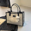 Women's black canvas tote bag with rhombus pattern and shoulder strap