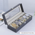 Grey leather watch storage box with clear dustproof lid showing multiple watch compartments inside.