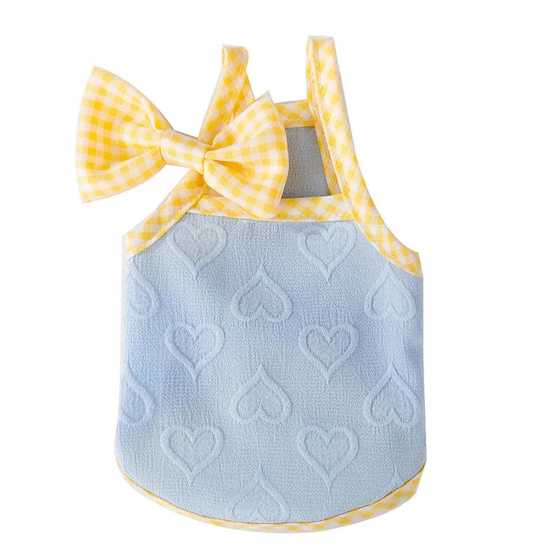 Small dog wearing blue elastic vest with heart texture and decorative bow
