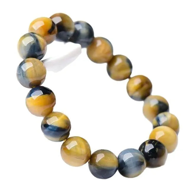 Close-up of a Fantasy Tiger Eye agate bracelet with round geometric beads on a wrist.