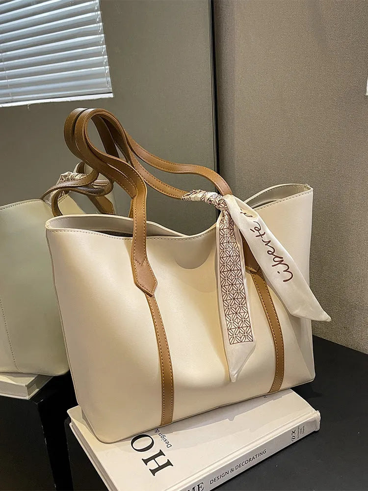Large soft tote shoulder bag in khaki colour with a crossbody strap and visible sewing line detail.