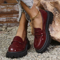 Women's plus size black slip-on loafers with a chunky mid-heel and rubber sole.