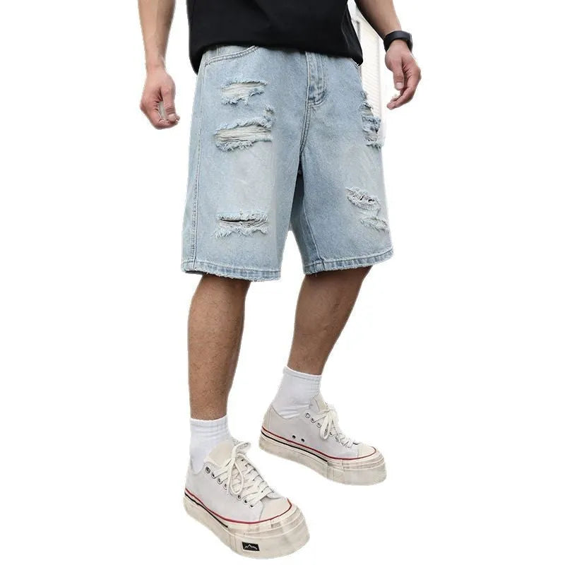 Light blue ripped denim shorts with distressed detailing and loose straight leg fit on a mannequin.
