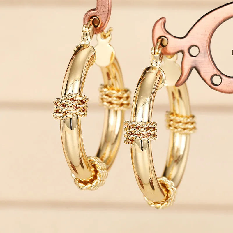 Golden geometric ear clip earrings with ring and line design elements made from copper