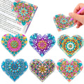 Six handmade PU leather bookmarks with crystal and floral corner designs on a book.