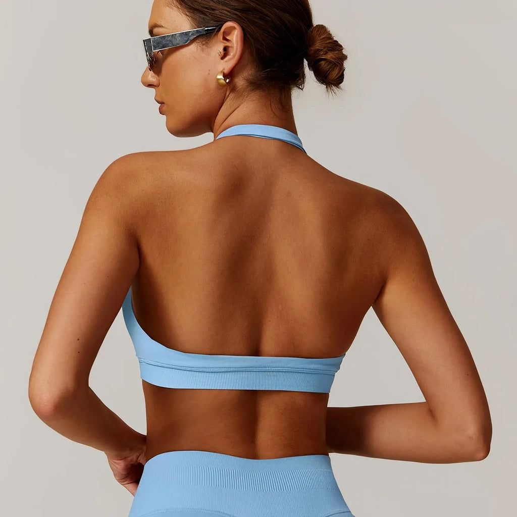 Women's black halter yoga bra with hollow design and built-in chest pads on a mannequin.