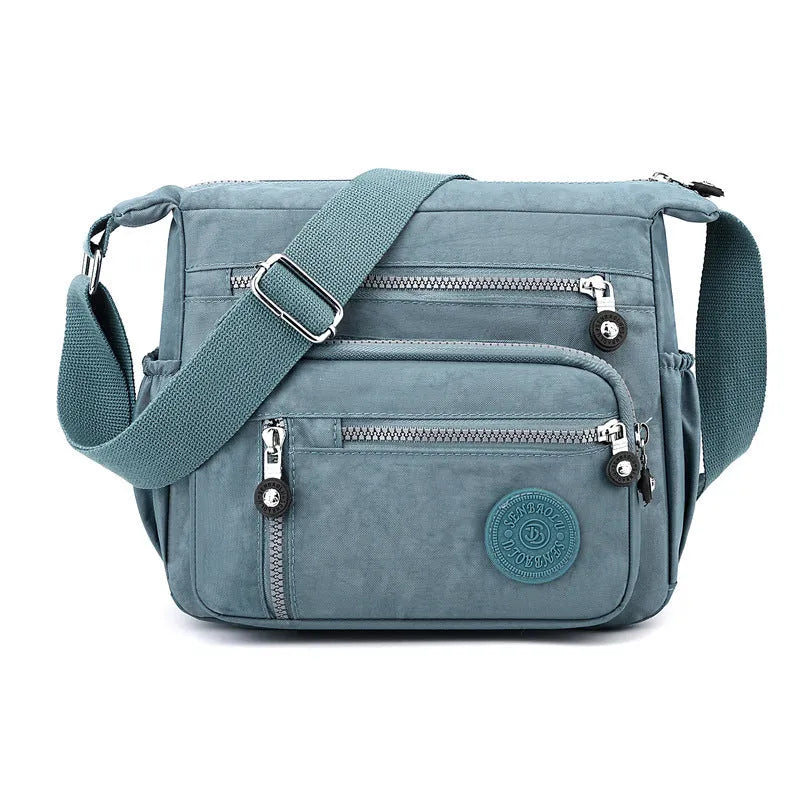 Lightweight nylon shoulder messenger bag in square vertical shape with single strap.