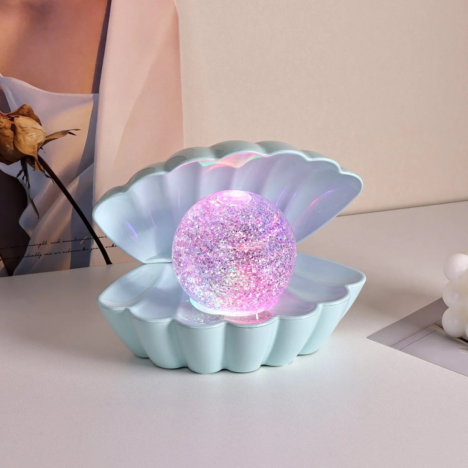 Shell-shaped small night lamp with neon ambience lighting on a table.