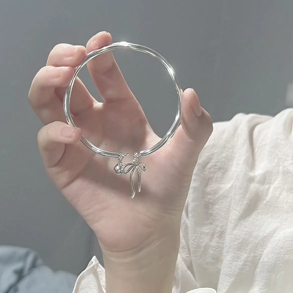 Silver adjustable bow bracelet with bell opening mechanism on zinc alloy chain