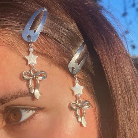 Silver metal alloy star bow hair clip with electroplated finish on neutral background