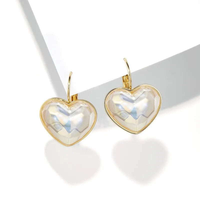 A pair of gold-coloured clip-on earrings with a metallic finish and natural styling.