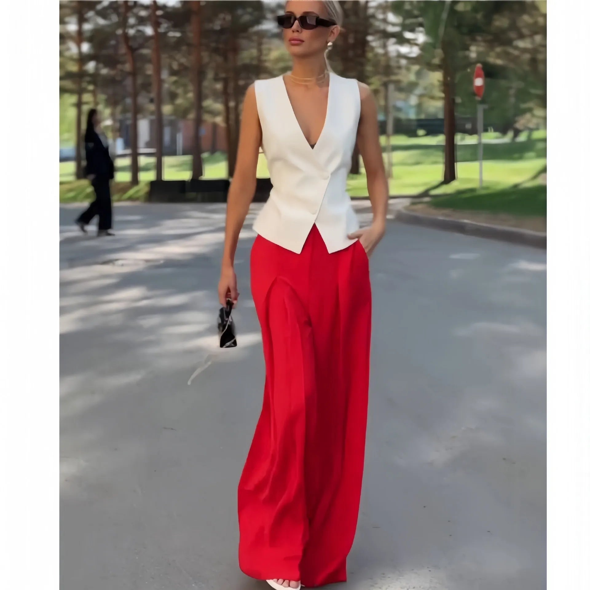 Women's beige two-piece set with deep V-neck sleeveless top and high-waisted wide-leg trousers.
