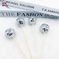 Glass disco ball cake decoration on a wooden stick, shown in different sizes.