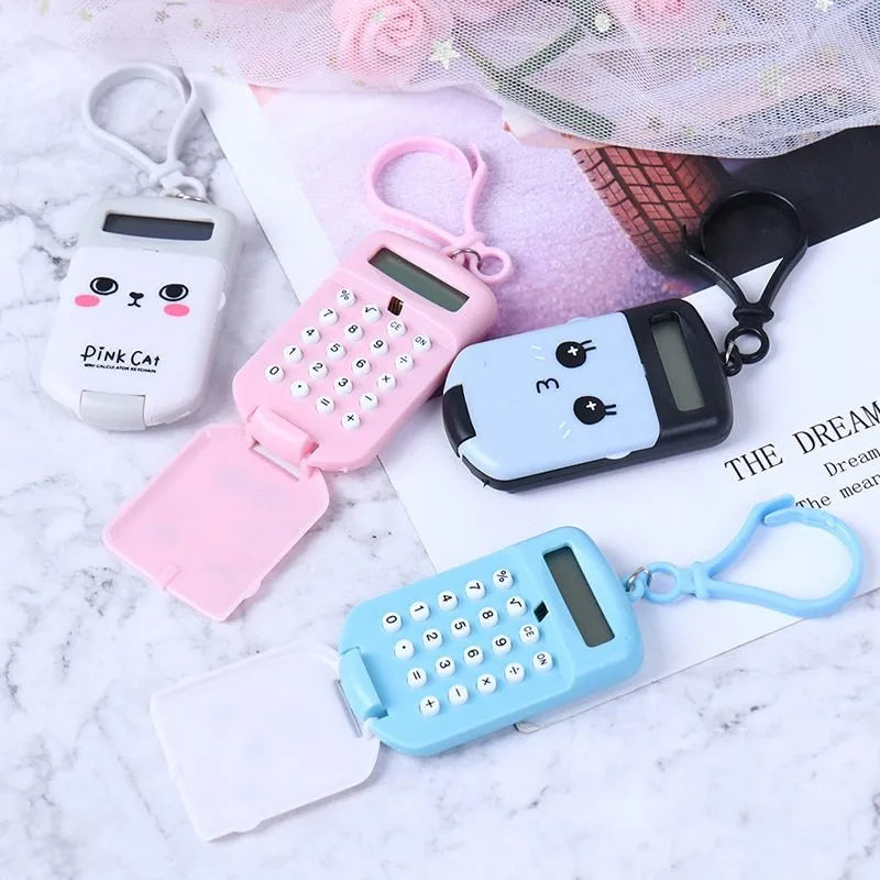 Creative cookie-shaped cute mini plastic calculator in black with key ring on a desk