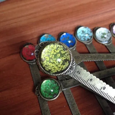 Handmade dried flower bookmark with ruler showing lace flowers, daffodils, and clover at 12cm length
