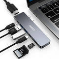 Silver aluminium USB-C hub adapter with SD card slot, HDMI, USB ports, and Thunderbolt 3 connector.