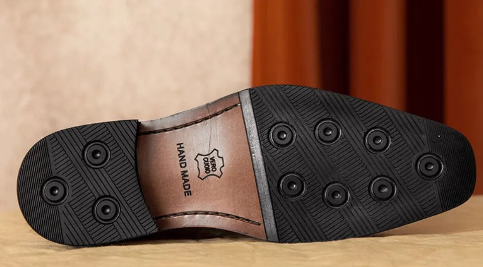 Men's black genuine leather slip-on loafers with fringed detailing and a rubber sole, shown from a side view.