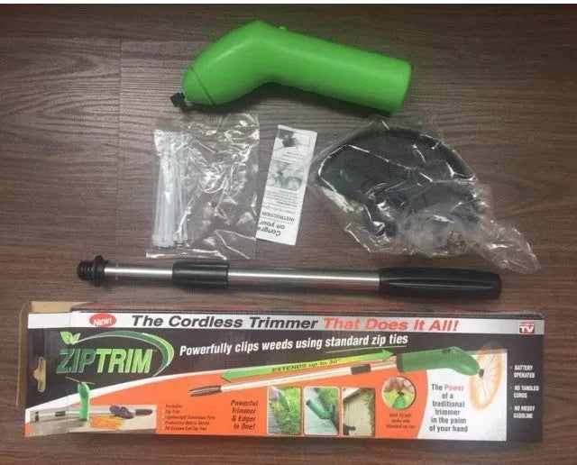 Cordless handheld lawn trimmer with extension pole and protective shield on green grass