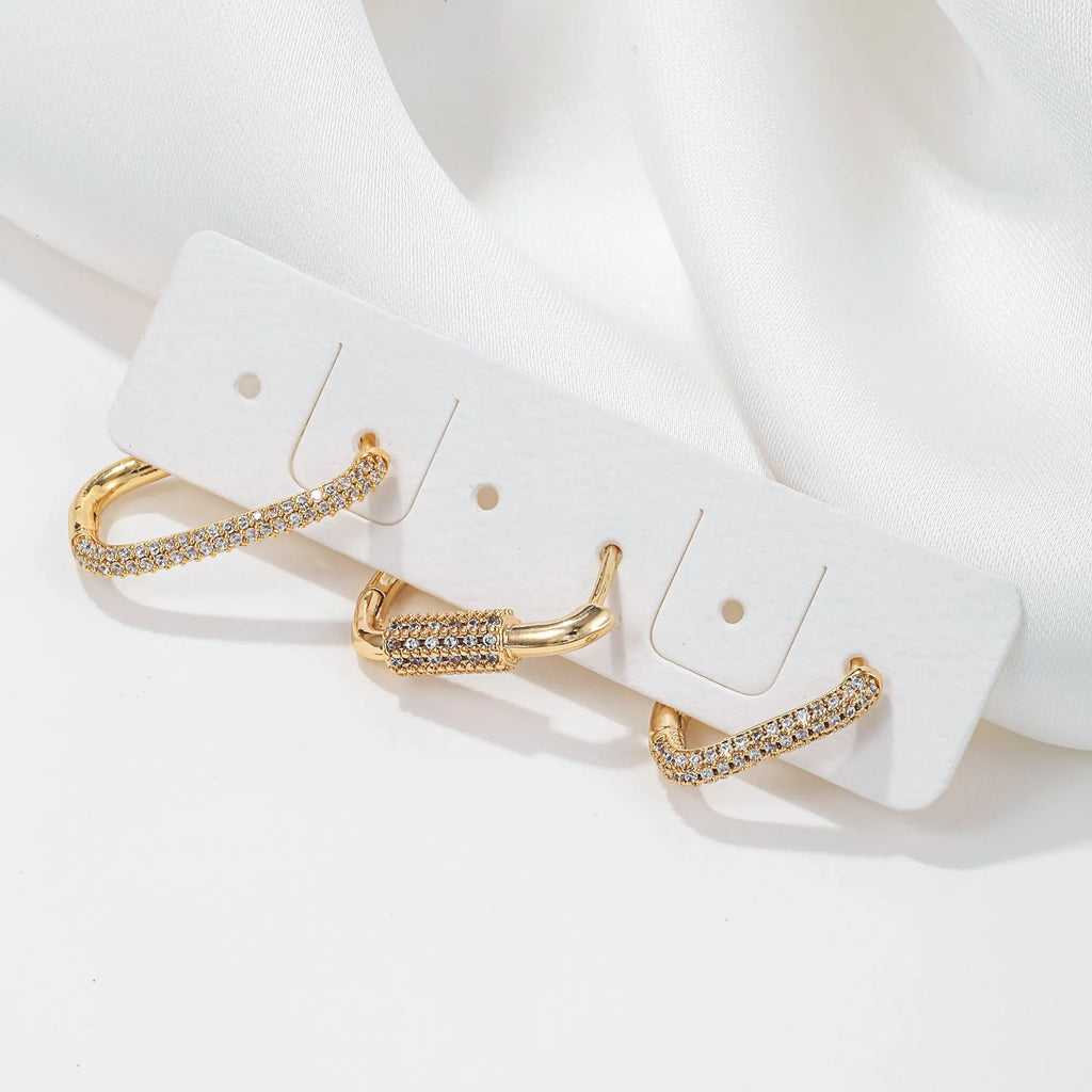 Three geometric copper ear clips with micro inlaid zircon detailing in gold and white finishes