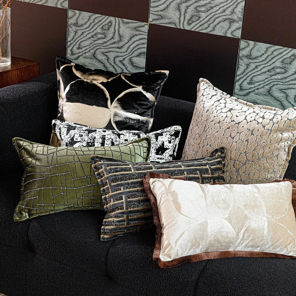 Black and gold abstract pattern flannel pillow cover on a grey sofa.