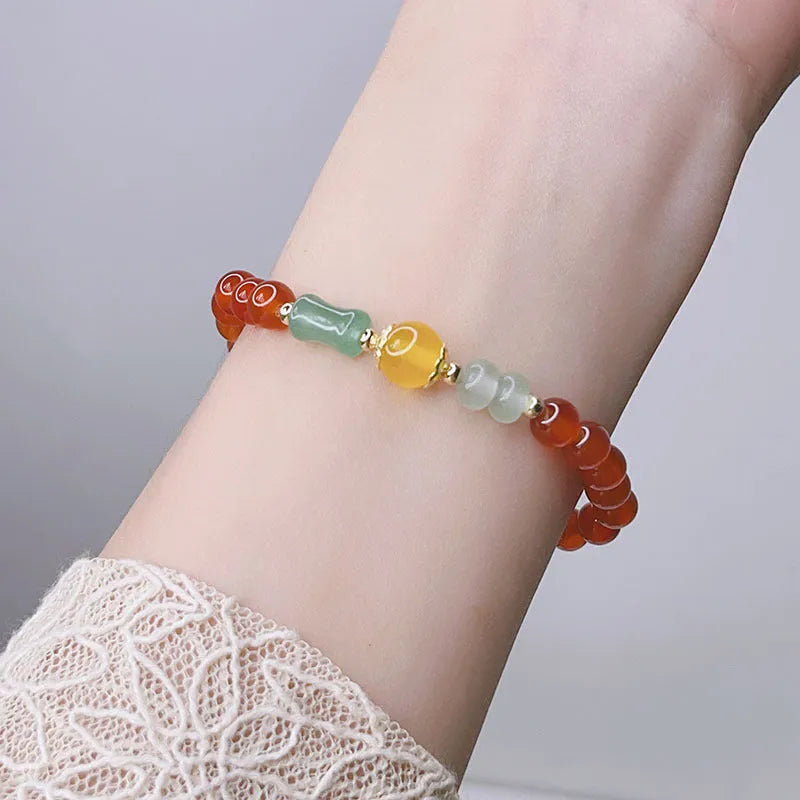 Handmade red agate women's bracelet with dragon design on a wrist.
