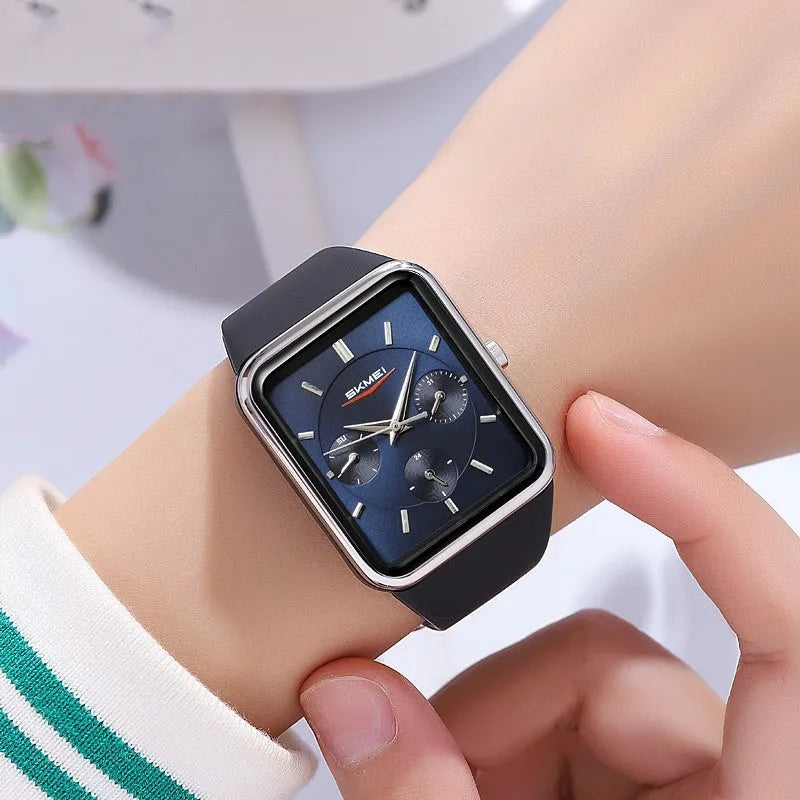 Square analogue silicone watch for women in white rose gold colour on a wrist, showing slim profile.