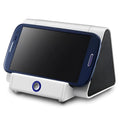 Small black and white wireless Bluetooth speaker with built-in charging cable.