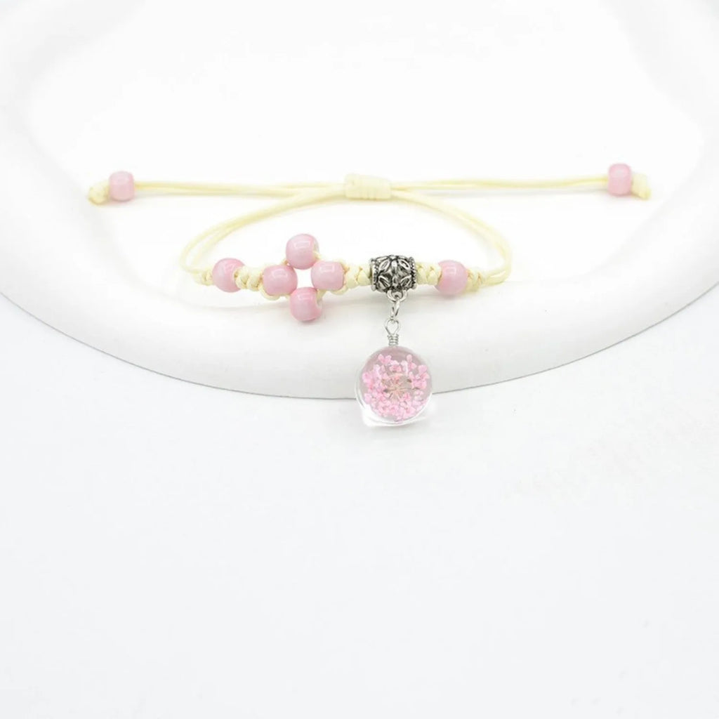 Glass dried flower bracelet with large 1.4cm beads containing real preserved flowers, in a hand-woven design.