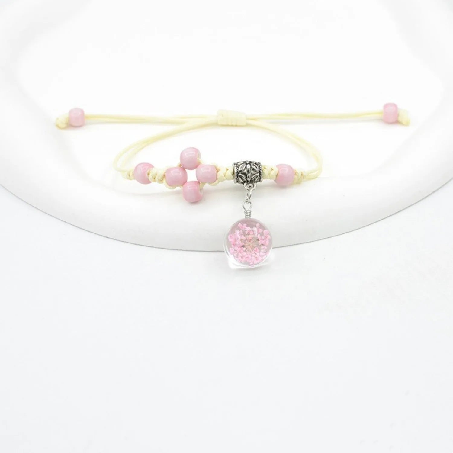Glass dried flower bracelet with large 1.4cm beads containing real preserved flowers, in a hand-woven design.