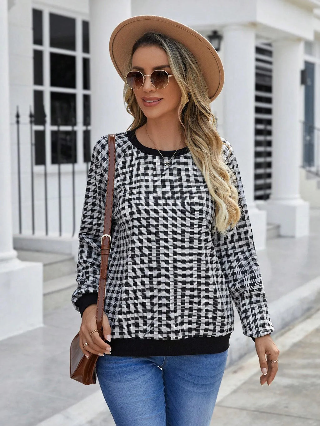 Black plaid pattern long sleeve polyester pullover sweater on a hanger.