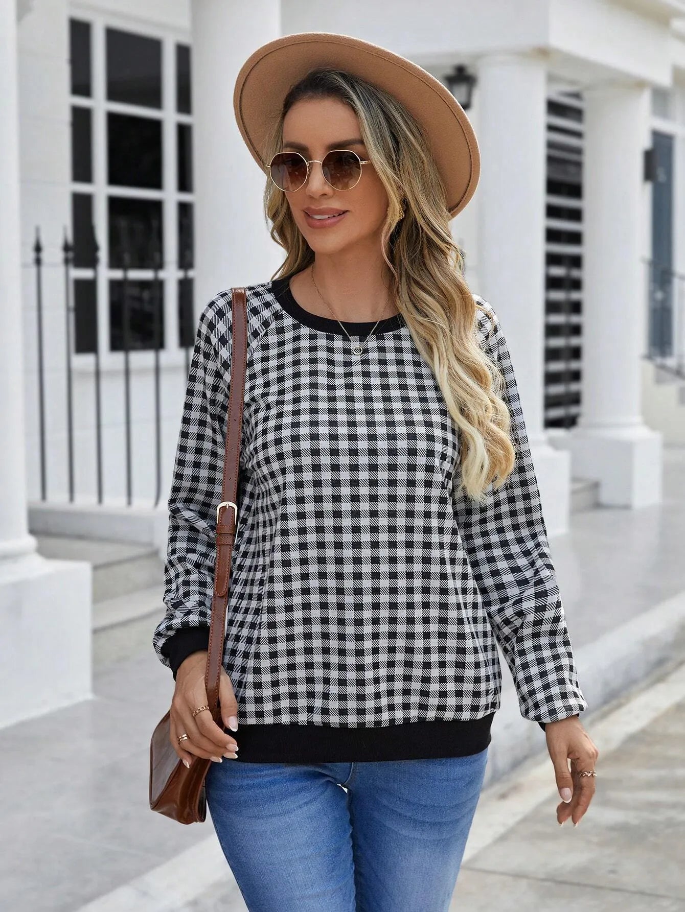 Black plaid pattern long sleeve polyester pullover sweater on a hanger.
