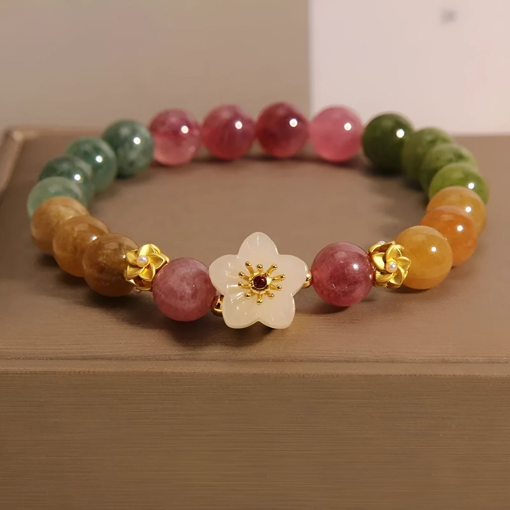 Tourmaline bracelet with floral or fu character design on a white background.