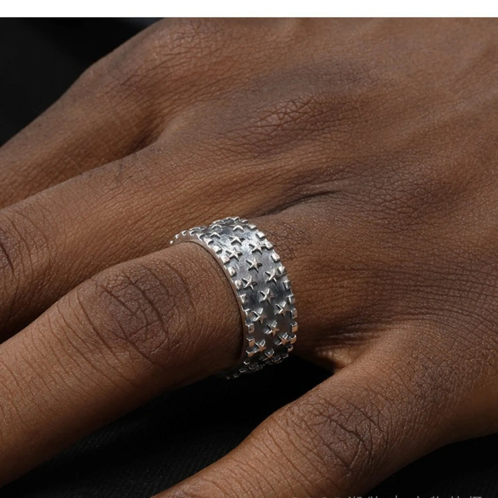 Adjustable sterling silver ring showing a geometric multi five pointed star pattern on the band.