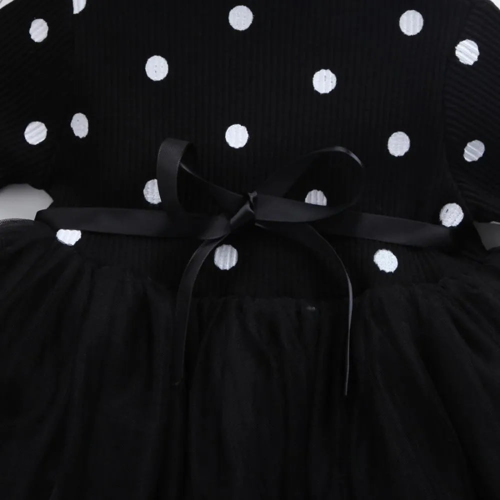 Baby girl in a long sleeve black tutu lace dress for a birthday party.