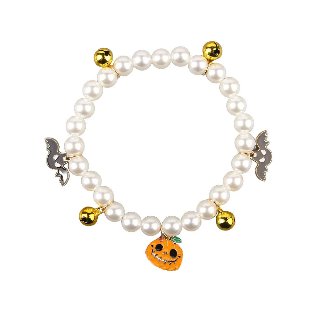 Halloween cat collar decoration with simulated pearls in purple ghost, skull, and smiling pumpkin designs.