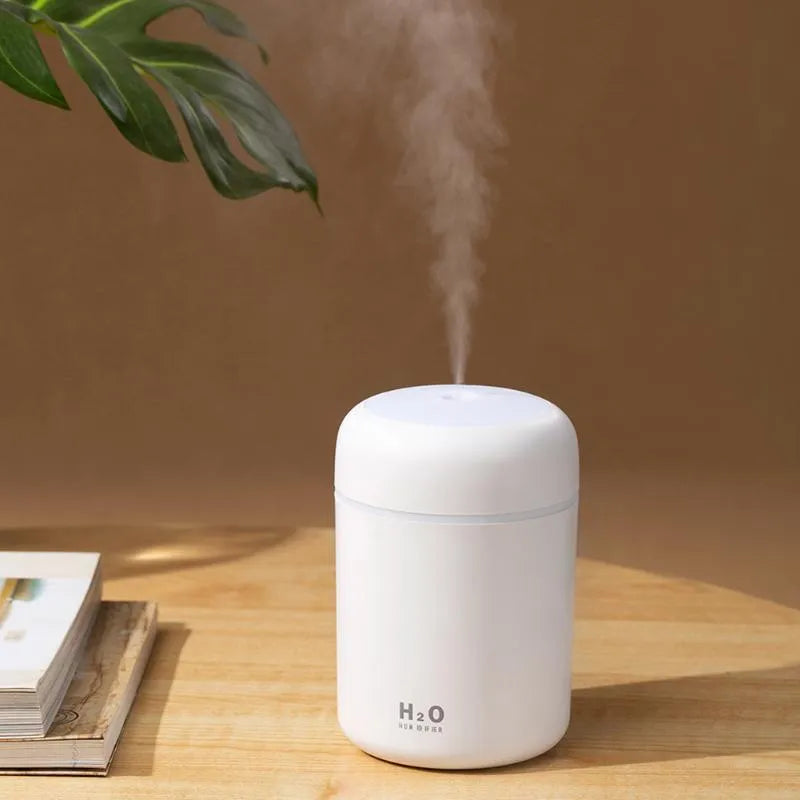 USB mini humidifier with colourful lights in pink, white, or navy blue colours on a desk