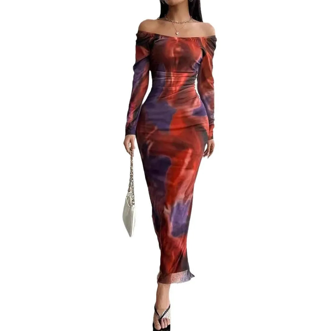 A woman wearing a long green mesh fishtail dress with pleats, a square collar, and a gradient colour print.