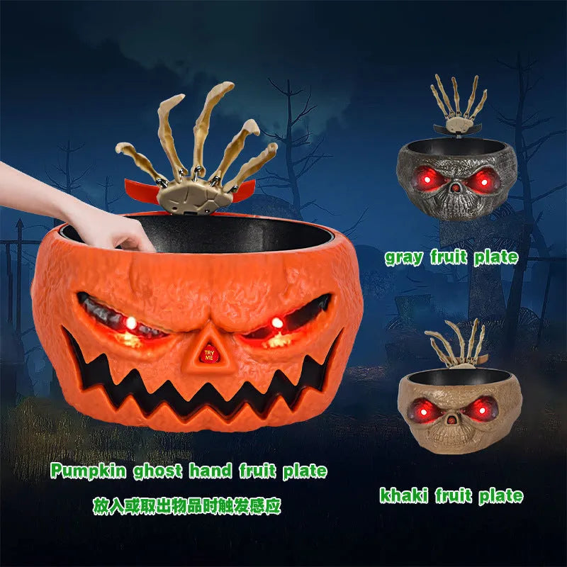 Plastic Halloween candy bowl with motion-activated skeleton hand and glowing red eyes on a table