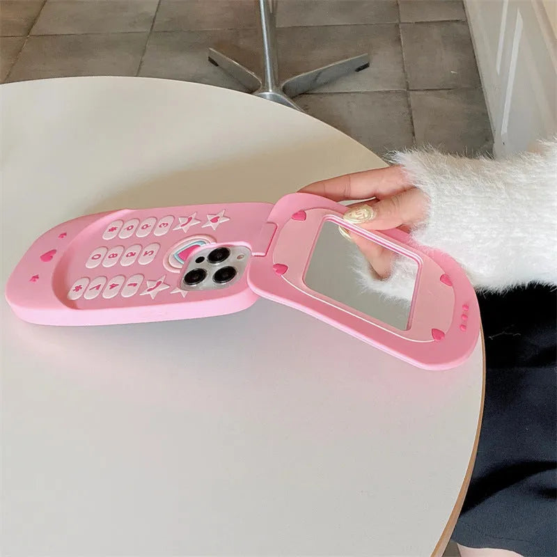 Pink silicone iPhone case shaped like a flip phone with a front mirror.