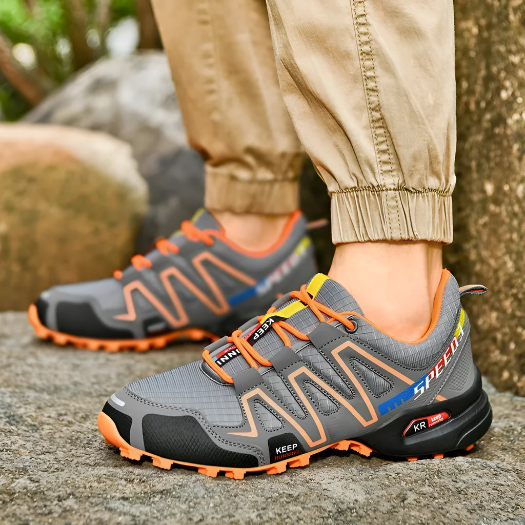 Men's low-top casual shoe in synthetic leather with a mesh lining and rubber sole, shown in grey orange colour.