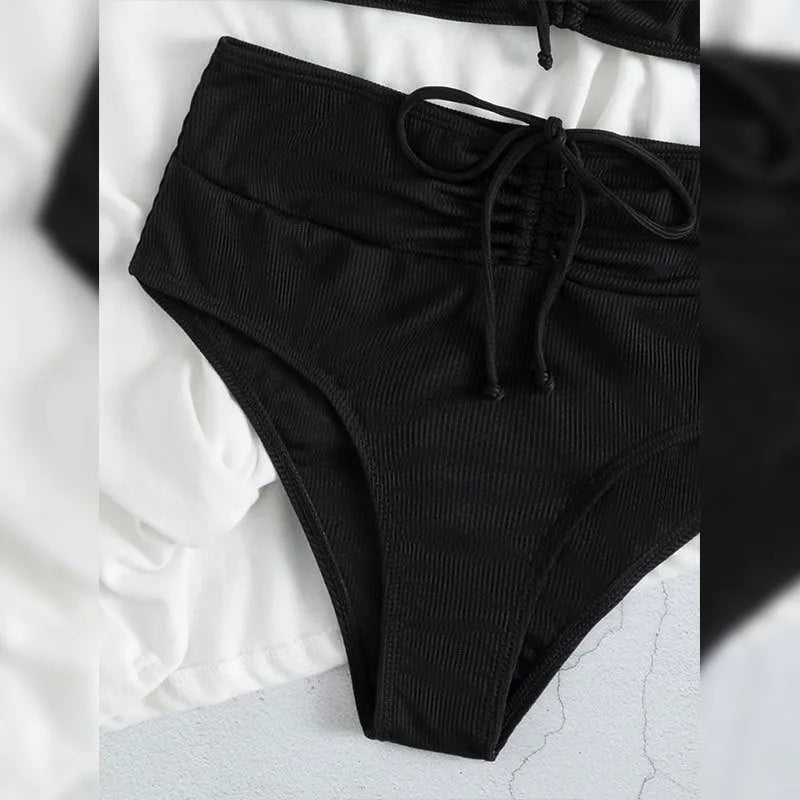 Black women's swimsuit set with sling bikini top and high-waist shorts with side splits