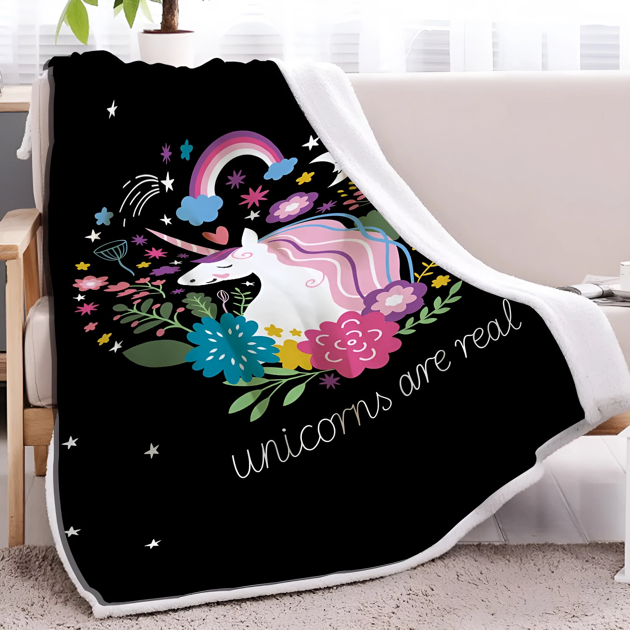 Black Sherpa fleece blanket with high weight, soft texture, and hemmed edges on a sofa