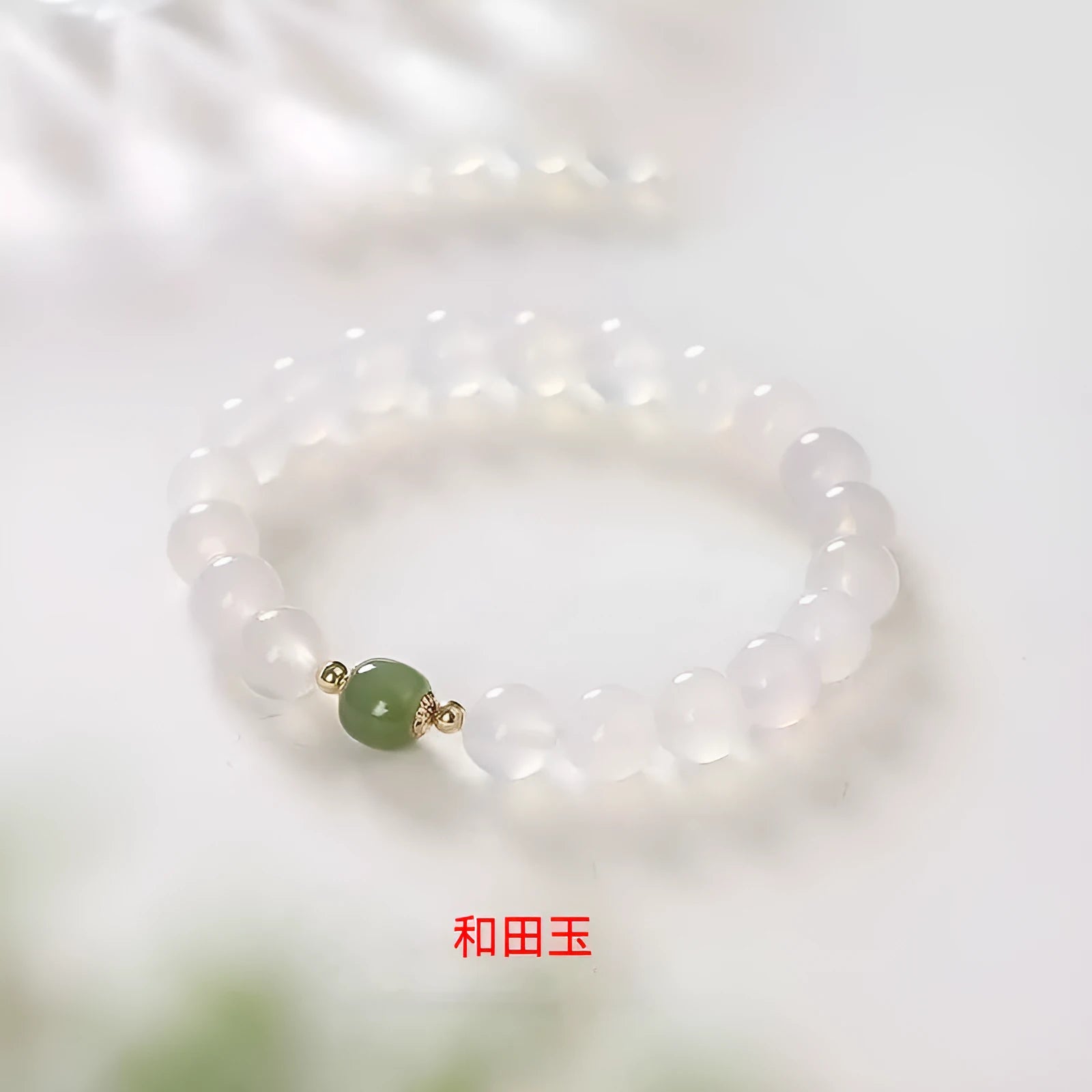 Handmade natural white agate crystal bracelet with cinnabar inlay on wrist, showing 8mm round beads.