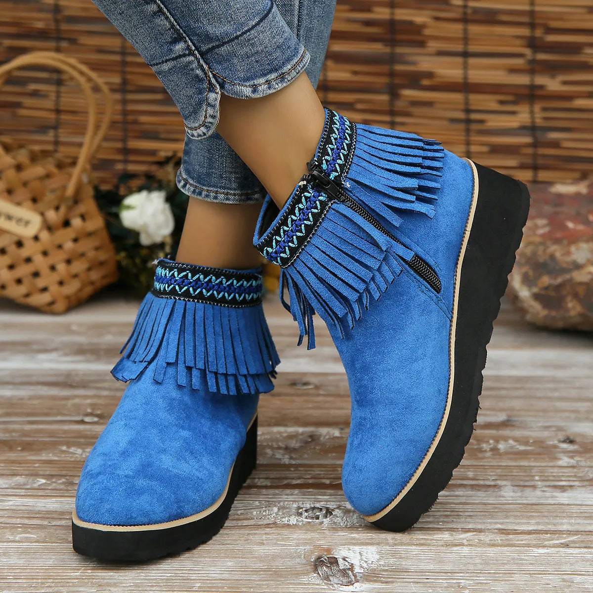 Women's black suede ankle boot with wedge heel, platform sole, side zip, and tassel detail.