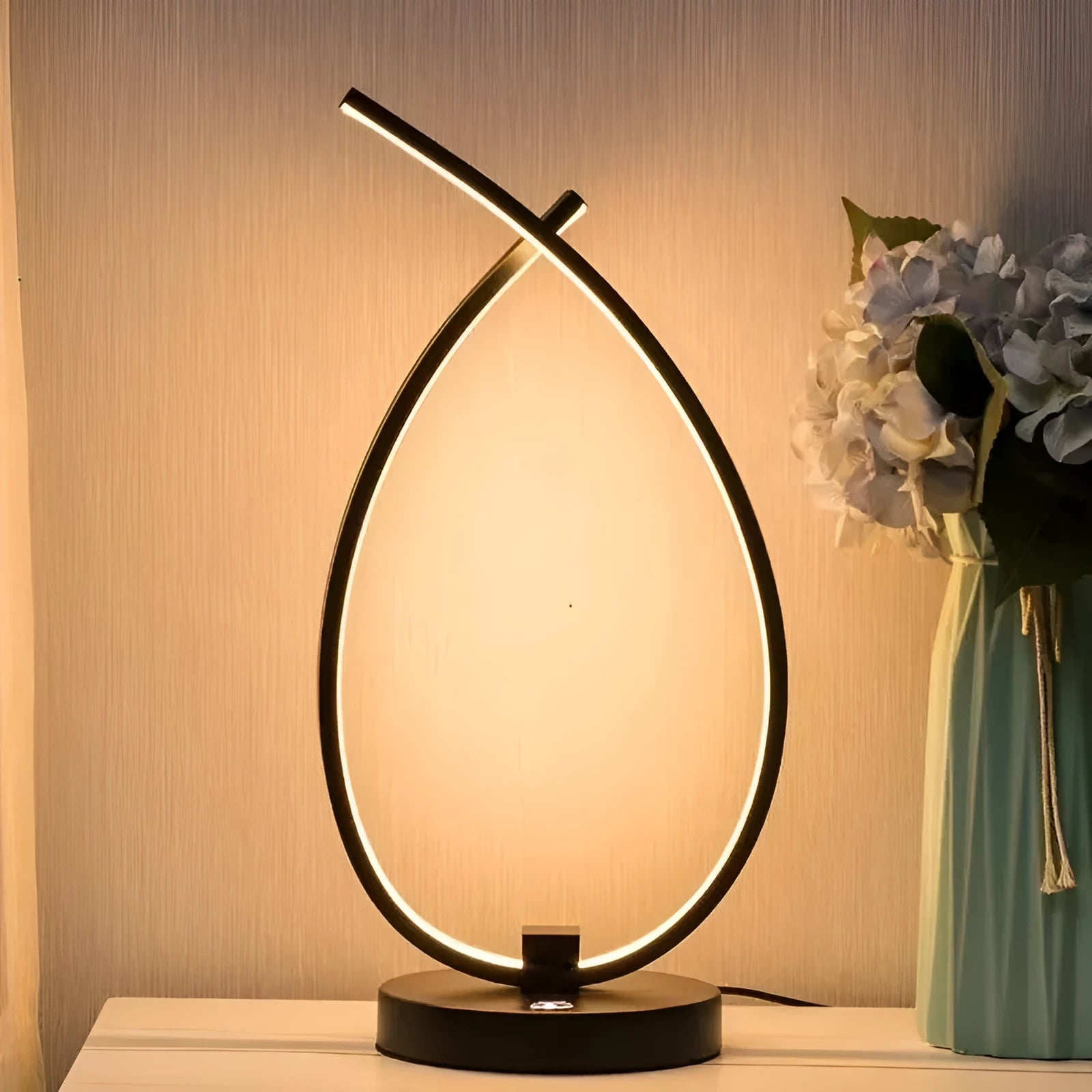 Black water drop shaped USB desk lamp with touch control on a wooden table