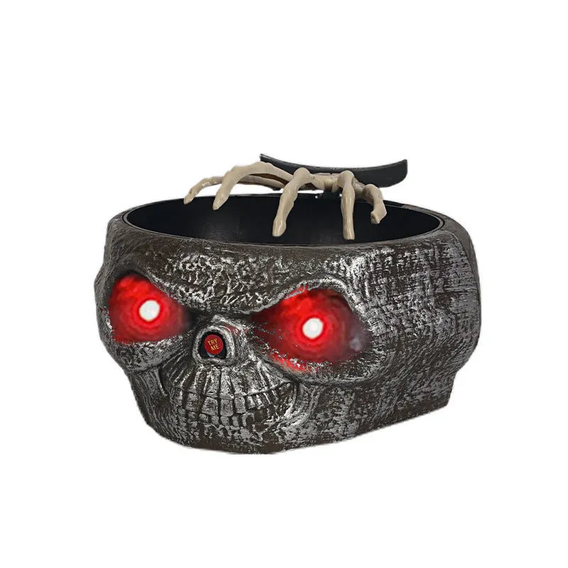 Plastic Halloween candy bowl with motion-activated skeleton hand and glowing red eyes on a table