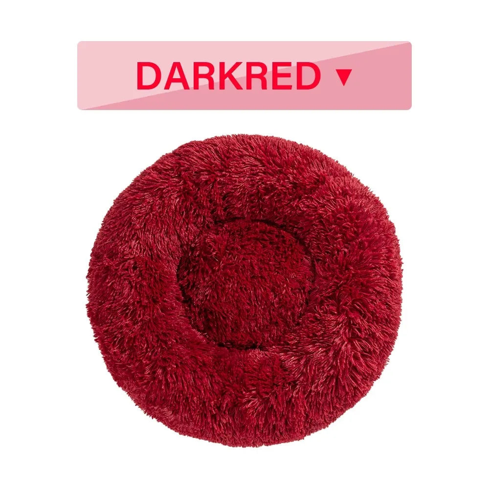 Fluffy donut-shaped dog bed in long plush material, shown in a grey colour, with a raised rim.